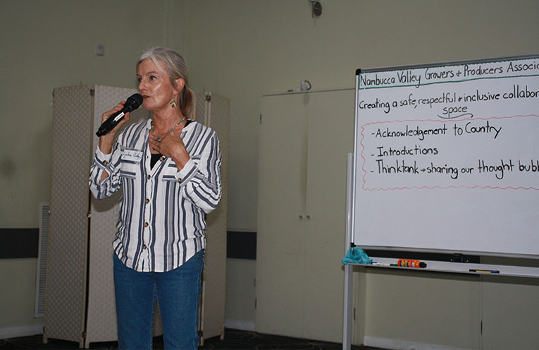 woman with a microphone standing in front of a whiteboard